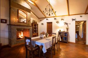 a dining room with a table and a fireplace at Laikipia farmstay Chui Cottage near Nanyuki - 2330 in Timau