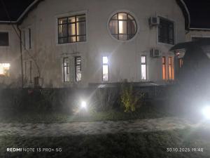 a house with two lights in front of it at night at Екохостел in Bishkek +1 photo