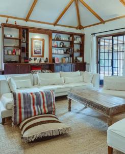 a living room with white couches and a coffee table at Laikipia farmstay Chui Cottage near Nanyuki - 2330 in Timau
