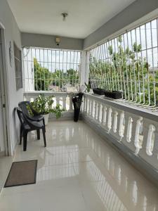 a room with a balcony with a chair and windows at Mi refugio cerca del aeropuerto in Santo Domingo