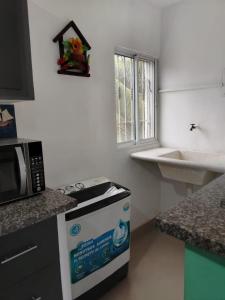 a kitchen with a stove and a microwave at Mi refugio cerca del aeropuerto in Santo Domingo