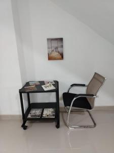 a black chair next to a table with a picture at Mi refugio cerca del aeropuerto in Santo Domingo +14 photos
