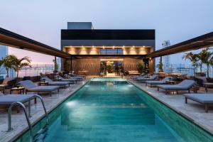 卡塔赫纳OZ Hotel Collection的一座带躺椅的游泳池和一座建筑