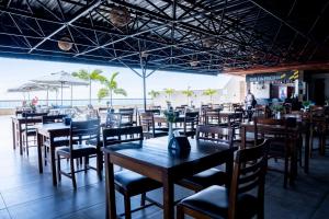 a restaurant with wooden tables and chairs and a beach at Studio-Apartment Center Pool Free Parking in Salvador