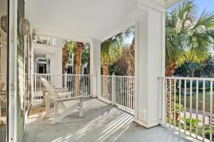 un porche blanco con una silla y palmeras en Pilot House 412, en Destin
