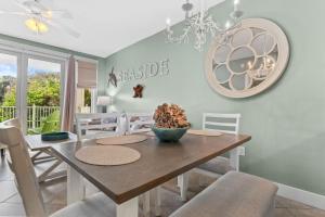 Un comedor con mesa y sillas de madera. en Pilot House 412, en Destin