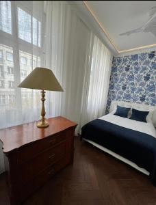 ポズナンにあるLuxury apartment in center town!のベッドルーム1室(ベッド1台、ドレッサーのランプ付)