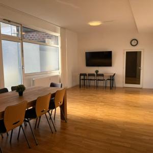 Großes Zimmer mit einem Tisch und Stühlen sowie einem TV. in der Unterkunft T&K Apartments - Comfortable 4 and 5 room Apartments - 20min Fair Messe CGN in Overath