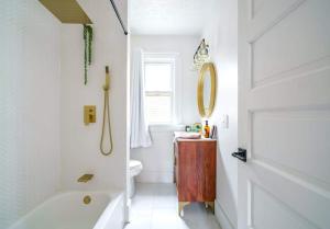 a bathroom with a tub and a toilet and a sink at Jungle House Luxury Homes - Columbus Downtown Short North - Steps to Convention Center & Nationwide Arena - Sleeps up to 8 - Free Parking - Over 5,800 Five Stars in Columbus