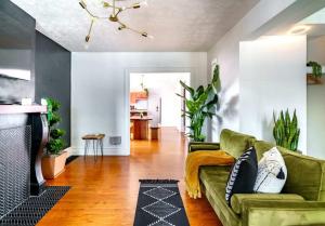 a living room with a green couch and a fireplace at Jungle House Luxury Homes - Columbus Downtown Short North - Steps to Convention Center & Nationwide Arena - Sleeps up to 8 - Free Parking - Over 5,800 Five Stars in Columbus +29 photos