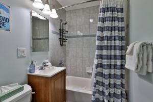 ein Badezimmer mit Waschbecken und Duschvorhang in der Unterkunft Roaring Bear Cabin - Secluded Killington Retreat with Hot Tub and Fire Pit in Sherburne Center + 24 Fotos