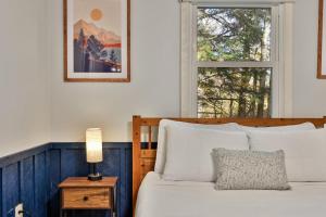 ein Schlafzimmer mit einem Bett und einem Fenster in der Unterkunft Roaring Bear Cabin - Secluded Killington Retreat with Hot Tub and Fire Pit in Sherburne Center