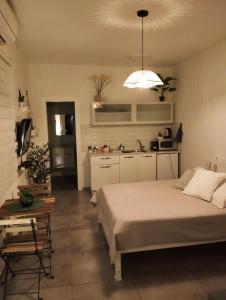 a bedroom with a large bed and a kitchen at Dekel Dom Baharava in Beʼer Ora
