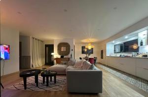 een woonkamer met een bank en een tafel bij Chambres dans la Villa Larros in Gujan-Mestras