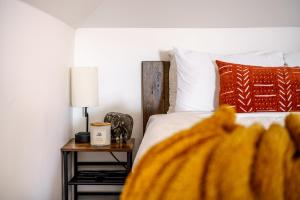 a bedroom with a bed and a table with a lamp at Jungle House Columbus - Luxury Downtown Homes Free Parking in Columbus