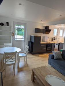 a kitchen and living room with a table and a couch at Cozy apartment with terrace in Crach