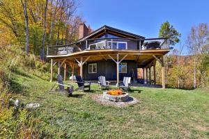 a house on a hill with chairs and a fire pit at RoundTop Chalet - Hot Tub, Fire Pit & Mountain Views near Killington & Okemo in Plymouth