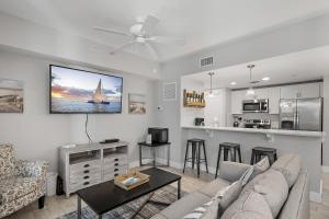 a living room with a couch and a kitchen at Pilot House 413 in Destin