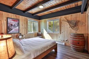 a bedroom with a bed and a wooden wall at RoundTop Chalet - Hot Tub, Fire Pit & Mountain Views near Killington & Okemo in Plymouth