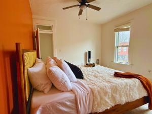 a bedroom with a bed with pillows and a ceiling fan at Jungle House Luxury Stays - Columbus Downtown Short North in Columbus