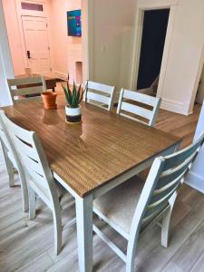 a wooden dining room table with chairs and a plant on it at Jungle House Luxury Stays - Columbus Downtown Short North in Columbus