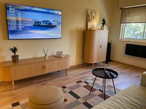 a living room with a flat screen tv on the wall at BestHomeStay-Santiago do Cacém in Santiago do Cacém