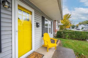 una porta gialla su una casa con una sedia gialla di The Washington Cottage - 6ppl a Harrison