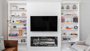 a living room with a tv on a white wall at Downtown Condo - 2BR 2BA Walk to Everything in Raleigh +22 photos