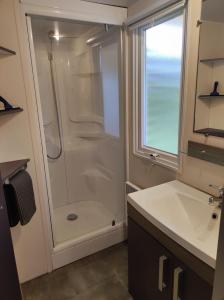 ein Badezimmer mit Dusche und Waschbecken in der Unterkunft Mobilhome cosy, spacieux au bord de l'Eure in Ivry-la-Bataille