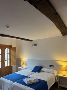 a bedroom with a large bed with blue sheets at Pension Via-Stella in Santiago de Compostela