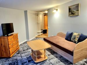 a living room with a couch and a tv at Antano Vila in Palanga