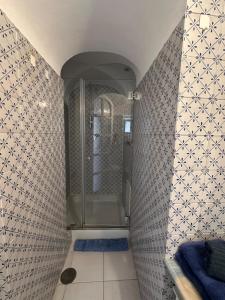 a shower in a bathroom with a tile wall at Center Apartment Capri in Capri