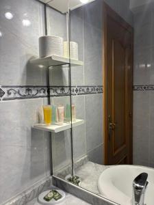 a bathroom with a sink and a toilet and a mirror at Pension Via-Stella in Santiago de Compostela +25 photos