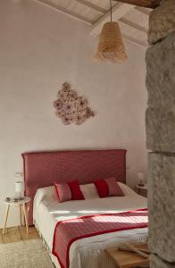 a bed with a red headboard in a bedroom at Casa S'Urtzula in Sini