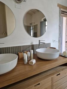 a bathroom with two sinks and two mirrors at Casa S'Urtzula in Sini +11 photos