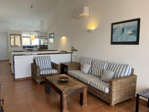 a living room with a couch and two chairs and a table at Riera Rossello 1 by SOM Menorca in Fornells