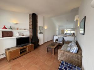 a living room with a television and a fireplace at Riera Rossello 1 by SOM Menorca in Fornells
