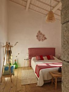 a bedroom with a large bed with red pillows at Casa S'Urtzula in Sini