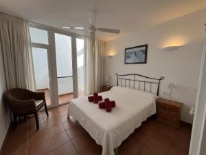 a bedroom with a bed with red pillows on it at Riera Rossello 1 by SOM Menorca in Fornells
