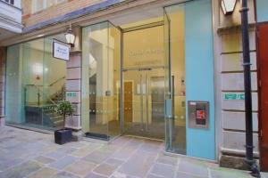 a glass door of a building with a potted plant in front at The Cardiff Central Pad – Stylish 2-Bed Apartment in Cardiff