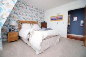 a bedroom with a large bed and a blue wall at The Cardiff Central Pad – Stylish 2-Bed Apartment in Cardiff