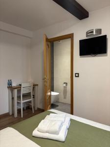 a bedroom with a bed and a desk and a bathroom at Pension Via-Stella in Santiago de Compostela