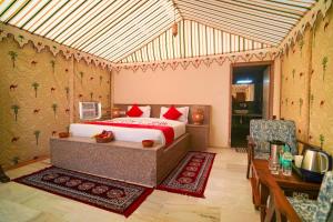 a bedroom with a bed and a table and chairs at Jaisan Heritage Desert Camp in Jaisalmer