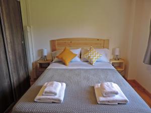 a bedroom with a bed with two towels on it at Río Epuyén Aparts in El Hoyo
