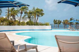 a swimming pool with chairs and palm trees at Royal Islander Club Resort La Terrasse in Lowlands +99 photos