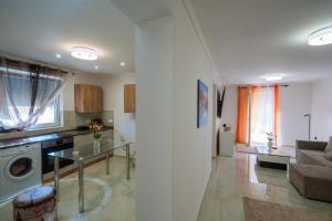 une cuisine et un salon avec un canapé et une table dans l'établissement Non stop apartman 1, à Kaposvár