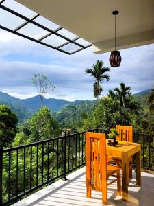 a wooden table and chairs on a balcony with a view at Tunnel Top Inn Ella in Ella