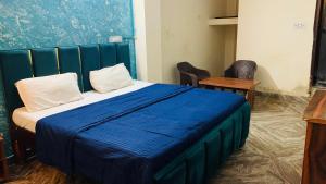 a bedroom with a bed with a blue blanket at Glory hotel in Noida