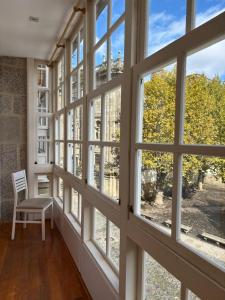 a room with large windows and a chair at Pension Via-Stella in Santiago de Compostela