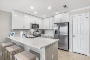 eine Küche mit weißen Schränken und einem Edelstahlkühlschrank in der Unterkunft San Remo 403 in Santa Rosa Beach